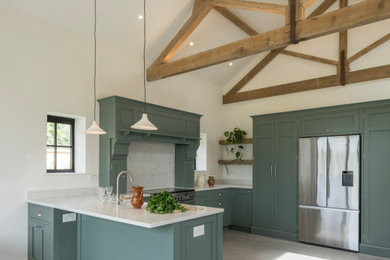 Photo of a large classic l-shaped kitchen/diner in Sussex with shaker cabinets, green cabinets, white splashback, no island and white worktops.