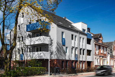 Großes, Vierstöckiges Modernes Wohnung mit Putzfassade, blauer Fassadenfarbe, Satteldach, Ziegeldach und schwarzem Dach