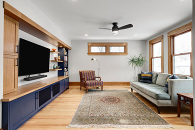 Inspiration for a large contemporary open concept light wood floor family room remodel in Minneapolis with gray walls and a media wall