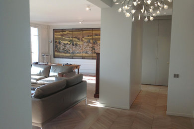 Idées déco pour une salle à manger ouverte sur le salon contemporaine de taille moyenne avec un mur beige, parquet clair, une cheminée standard, un manteau de cheminée en pierre et un sol beige.