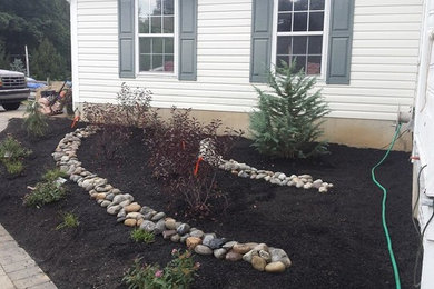 Photo of a large traditional drought-tolerant and partial sun front yard river rock walkway in Philadelphia.