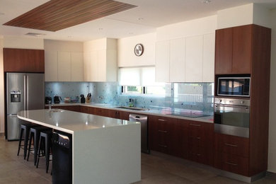This is an example of a modern galley eat-in kitchen in Darwin with an undermount sink, medium wood cabinets, quartz benchtops, multi-coloured splashback, stainless steel appliances and with island.