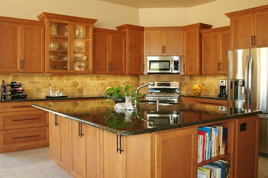 Large elegant u-shaped ceramic tile kitchen photo in Other with a double-bowl sink, shaker cabinets, light wood cabinets, granite countertops, beige backsplash, cement tile backsplash, stainless steel appliances and an island