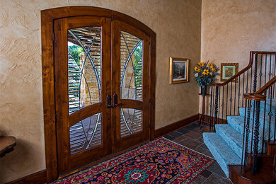 Entryway - mid-sized rustic dark wood floor entryway idea in Austin with beige walls and a brown front door