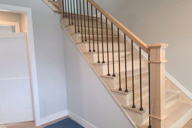 Ejemplo de escalera en L contemporánea de tamaño medio con escalones de madera, contrahuellas de madera y barandilla de varios materiales
