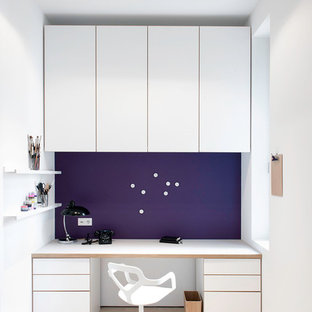 This is an example of a mid-sized scandinavian study room in Hamburg with light hardwood floors, a built-in desk, purple walls and no fireplace.