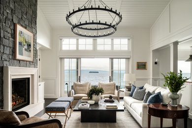 Example of a large transitional open concept dark wood floor, wainscoting, brown floor, exposed beam, shiplap ceiling and vaulted ceiling living room design in Burlington with a standard fireplace, a stone fireplace and white walls