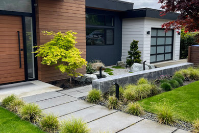 Imagen de jardín moderno de tamaño medio en patio delantero con roca decorativa, exposición total al sol y adoquines de hormigón