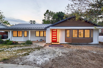 Example of a mid-sized trendy white one-story stucco exterior home design in San Francisco with a metal roof