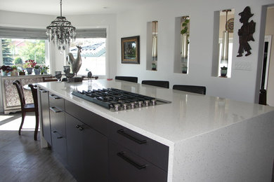 Inspiration for a mid-sized contemporary l-shaped porcelain tile and beige floor eat-in kitchen remodel in Edmonton with an undermount sink, flat-panel cabinets, gray cabinets, quartz countertops, white backsplash, glass tile backsplash, stainless steel appliances and an island