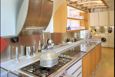 Eat-in kitchen - large contemporary u-shaped light wood floor and beige floor eat-in kitchen idea in Chicago with flat-panel cabinets, light wood cabinets, stainless steel countertops, gray backsplash, stainless steel appliances, no island, an integrated sink and mirror backsplash