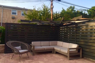 Small elegant backyard stone patio photo in New York with no cover