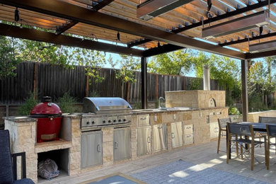 Patio kitchen - large backyard patio kitchen idea in San Francisco with a pergola