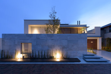 На фото: белый, большой, двухэтажный частный загородный дом в стиле модернизм с облицовкой из камня, плоской крышей и крышей из смешанных материалов с