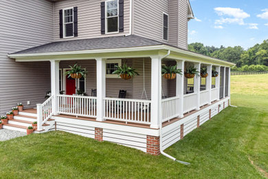 Example of a huge country gray one-story house exterior design with a shed roof, a shingle roof and a black roof