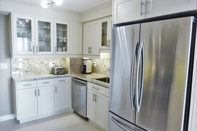 Eat-in kitchen - mid-sized transitional u-shaped porcelain tile and gray floor eat-in kitchen idea in Toronto with an undermount sink, glass-front cabinets, white cabinets, granite countertops, gray backsplash, stone slab backsplash, stainless steel appliances and a peninsula