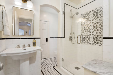 Mid-sized transitional 3/4 black and white tile and ceramic tile ceramic tile, white floor and single-sink alcove shower photo in Orange County with open cabinets, white cabinets, a one-piece toilet, white walls, a pedestal sink, a hinged shower door, white countertops and a freestanding vanity