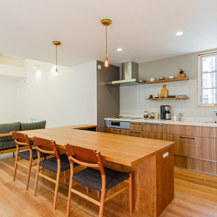 Photo of a mid-sized modern open plan kitchen in Kobe with medium hardwood floors, brown floor and wallpaper.