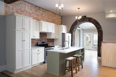 Example of a mid-sized trendy galley light wood floor open concept kitchen design in Other with a single-bowl sink, recessed-panel cabinets, green cabinets, marble countertops, multicolored backsplash, stainless steel appliances and an island