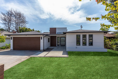Large minimalist white one-story stucco exterior home photo in San Francisco with a shingle roof and a black roof