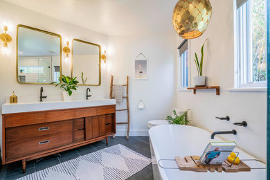 Inspiration for a small eclectic master white tile and ceramic tile ceramic tile and gray floor bathroom remodel in Los Angeles with furniture-like cabinets, brown cabinets, a one-piece toilet, white walls, an undermount sink, quartz countertops, a hinged shower door and white countertops