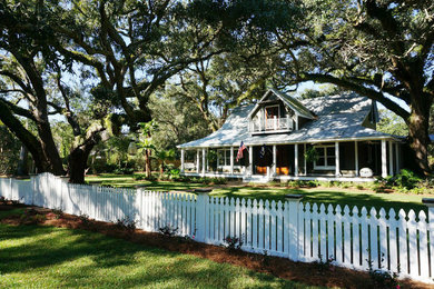 Example of a large classic green two-story wood gable roof design in Miami
