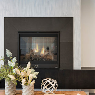 ミネアポリスの中サイズのモダンスタイルのおしゃれな地下室 (半地下 (窓あり) 、グレーの壁、カーペット敷き、横長型暖炉、コンクリートの暖炉まわり、グレーの床) の写真