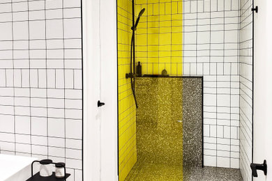 Imagen de cuarto de baño principal minimalista de tamaño medio con bañera exenta, ducha a ras de suelo, paredes blancas, suelo de terrazo, suelo gris y ducha abierta