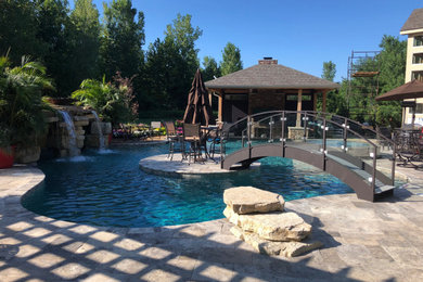 Example of a large beach style backyard stone and custom-shaped natural pool house design in Columbus