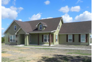 Green two-story house exterior idea in Austin with a shingle roof