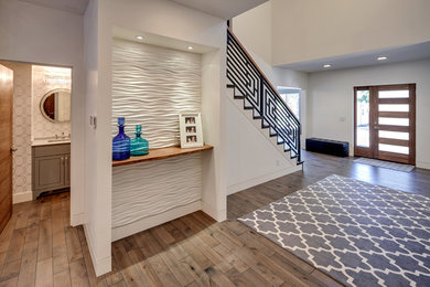 Example of a large trendy dark wood floor and brown floor entryway design in Portland with white walls and a dark wood front door
