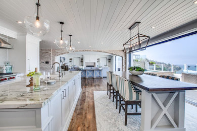 Photo of an expansive beach style galley open plan kitchen in Los Angeles with shaker cabinets, grey cabinets, marble benchtops, medium hardwood floors, multiple islands, multi-coloured floor and multi-coloured benchtop.