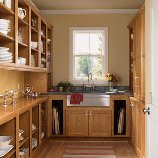 Mittelgroße Landhaus Küche ohne Insel in U-Form mit hellbraunen Holzschränken, Vorratsschrank, Landhausspüle, Schrankfronten im Shaker-Stil, Arbeitsplatte aus Holz, Küchengeräten aus Edelstahl, braunem Holzboden und braunem Boden in Sonstige