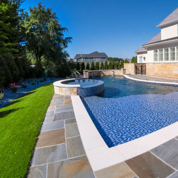 Naperville, IL freeform swimming pool with hot tub, large sunshelf, glass tile