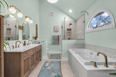 Mid-sized beach style master gray tile and porcelain tile mosaic tile floor, beige floor, double-sink and vaulted ceiling bathroom photo in Indianapolis with furniture-like cabinets, medium tone wood cabinets, a two-piece toilet, green walls, an integrated sink, quartzite countertops, a hinged shower door, white countertops, a niche and a freestanding vanity
