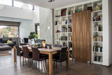 Offenes Modernes Esszimmer ohne Kamin mit weißer Wandfarbe, braunem Holzboden und braunem Boden in Bonn