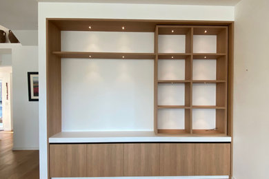 Diseño de salón para visitas abierto minimalista grande con paredes beige, suelo de madera en tonos medios y pared multimedia