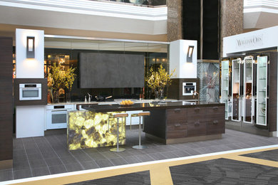 Пример оригинального дизайна: большая п-образная кухня в стиле модернизм с обеденным столом, накладной мойкой, стеклянными фасадами, коричневыми фасадами, столешницей из кварцита, фартуком цвета металлик, фартуком из стекла, белой техникой, полом из керамической плитки и островом