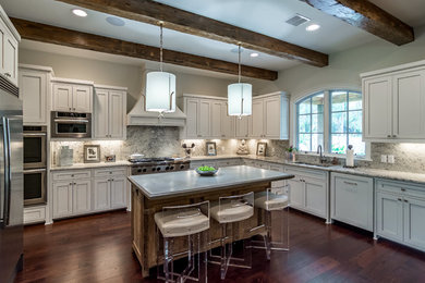 Enclosed kitchen - huge traditional l-shaped dark wood floor enclosed kitchen idea in New Orleans with an undermount sink, recessed-panel cabinets, white cabinets, granite countertops, marble backsplash, stainless steel appliances and an island