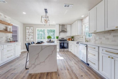 Large 1950s u-shaped light wood floor and brown floor eat-in kitchen photo in Dallas with a farmhouse sink, recessed-panel cabinets, white cabinets, quartz countertops, multicolored backsplash, stainless steel appliances, an island and multicolored countertops
