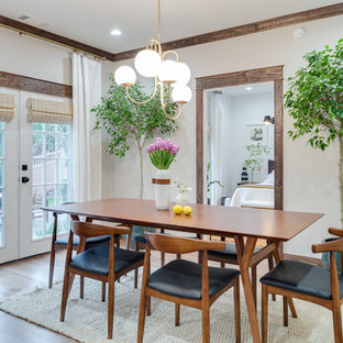 Design ideas for a mid-sized arts and crafts open plan dining in Atlanta with light hardwood floors, no fireplace, white walls and brown floor.