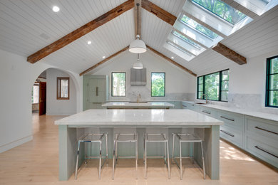 Large transitional light wood floor and shiplap ceiling enclosed kitchen photo in Dallas with a farmhouse sink, shaker cabinets, quartz countertops, white backsplash, quartz backsplash, stainless steel appliances, two islands and white countertops