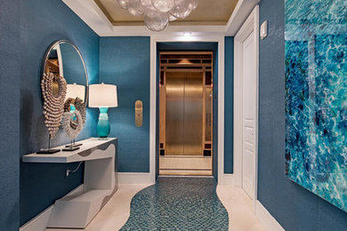Example of a large beach style blue floor entry hall design in Miami with blue walls