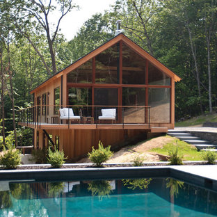 Rustik inredning av ett mellanstort brunt hus, med två våningar och glasfasad