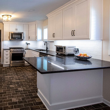 White Kitchen with Brown Quartz Countertop and Brick Flooring and Entryway