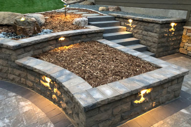 Design ideas for a mid-sized rustic concrete paver retaining wall landscape in Minneapolis.