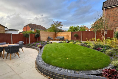 Inspiration for a medium sized contemporary back formal full sun garden in Other with natural stone paving and a wood fence.