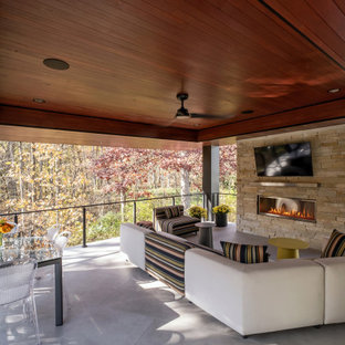 Immagine di un portico minimal di medie dimensioni e dietro casa con un caminetto, piastrelle, un tetto a sbalzo e parapetto in cavi