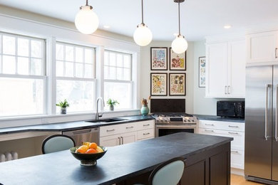 This is an example of a mid-sized transitional l-shaped eat-in kitchen in Boston with an undermount sink, recessed-panel cabinets, white cabinets, soapstone benchtops, stainless steel appliances, light hardwood floors and with island.