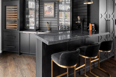 Eat-in kitchen - small contemporary u-shaped dark wood floor and brown floor eat-in kitchen idea in Philadelphia with an undermount sink, flat-panel cabinets, black cabinets, quartzite countertops, black backsplash, wood backsplash, paneled appliances, a peninsula and black countertops